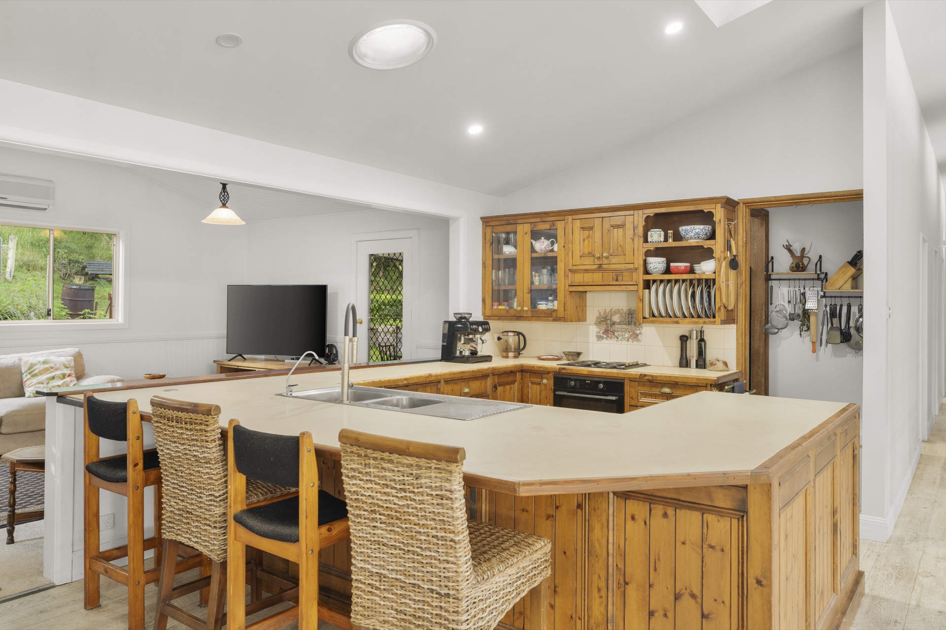 Kitchen with wicker barstools and forest views