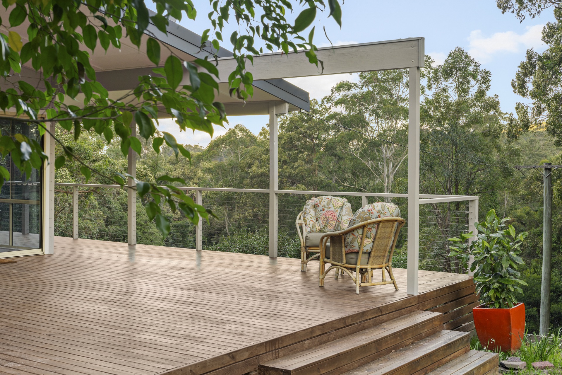 Rattan chairs on the deck overlooking the forest canopy